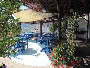 a restaurant with blue tables and chairs and flowers at Relais Bijoux Ischia in Ischia