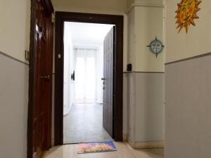 un pasillo con una puerta que conduce a una habitación con nevera en Casa Vacanze Macchi en Milán