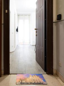 uma porta que dá para um corredor com um tapete no chão em Casa Vacanze Macchi em Milão