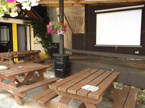 ベリークにあるFiddlestone Bar and B&Bの木製ピクニックテーブル2台、白いスクリーン