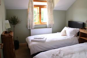 a bedroom with two beds and a window at Penrith Lodge in Stroud