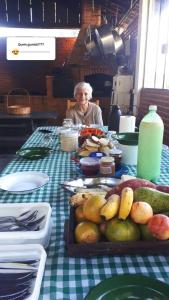 a woman sitting at a table with a table with food at Atma Anna in Piedade