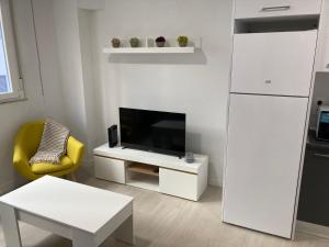 uma sala de estar com uma televisão e um frigorífico branco em VuT IMPERIAL LA RANITA SALMANTINA em Salamanca