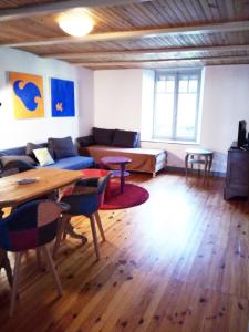 uma sala de estar com um sofá e uma mesa em Au grain de Celles em Celles-en-Bassigny
