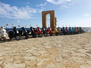 a row of scooters parked in front of a monument at Mahdia - Baghdadi - Laourient Apartments, restaurant, café in Mahdia