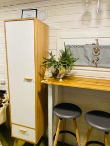 a kitchen with two stools at a table with a counter at Ambarcasa Farm - Дом для уединения in Kalman'