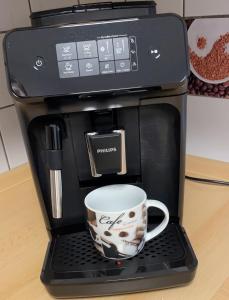 a coffee maker with a coffee cup on a keyboard at Ferienwohnung Havenwelten in Bremerhaven