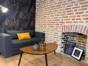 - un salon avec un canapé et une cheminée en briques dans l'établissement Chez Marcel, T2 lumineux, proche gare, à Rennes
