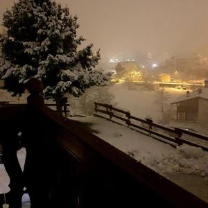 Eine Person steht neben einem Zaun im Schnee in der Unterkunft Agriturismo B&B Chèvres à Cheval in Aosta