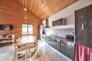 a kitchen with a wooden ceiling and a wooden table at Chalet de charme - Le Martinet in Ney