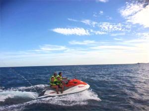 two people sitting on a jet ski in the ocean at Mahdia - Baghdadi - Laourient Apartments, restaurant, café in Mahdia