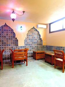 a room with wooden benches and a wall with tiles at Mahdia - Baghdadi - Laourient Apartments, restaurant, café in Mahdia
