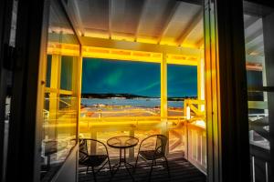a balcony with a table and chairs and a view of the ocean at Grand Arctic Resort in Överkalix