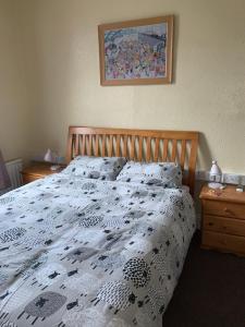 a bed with a black and white comforter on it at Brafferton Guest House in Hartlepool