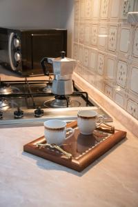 two coffee cups sitting on a tray on a counter at Tal Borc in San Vito al Torre