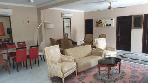 - un salon avec des chaises et une table ainsi qu'une salle à manger dans l'établissement MRI Residence 4 Bedroom Bungalow with Private Pool in Sg Buloh - No Pork & No Alcohol, à Merbau Sempak