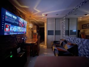 un soggiorno con divano e grande TV di Cozy Studio Hotel-like Condominium at Megatower Residences a Baguio