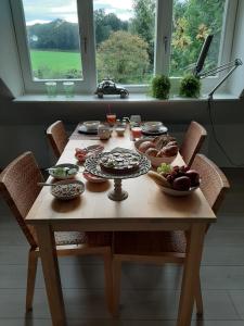 a table with plates of food on it with a window at B&b Hoogholtje in Onderdendam