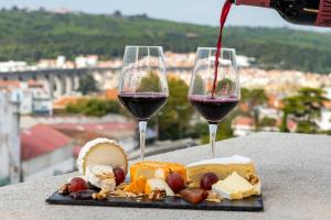 two glasses of wine sitting on a table with food at Smy Lisboa in Lisbon