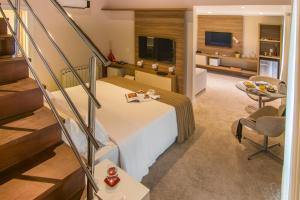 een slaapkamer met een bed en een woonkamer bij Modevie Boutique Hotel in Gramado