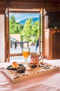uma mesa com uma bandeja de comida e um copo de sumo em Linaje Hotel Boutique & Relax em Lago Puelo
