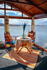 una mesa y dos sillas en un barco en Luz del Titicaca Lodge, en Puno