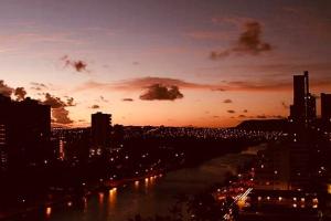 a view of a city with a river at sunset at Hawaiian Monarch 1611 condo in Honolulu