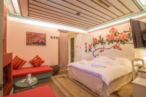 1 dormitorio con 1 cama con un mural de flores en la pared en Pirrion Wellness Boutique Hotel, en Ano Pedina