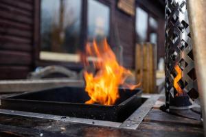 a fire in a grill with flames in it at The Woodland Lodge - Wood Fired Hot Tub and Firepit in Hambleton