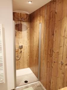 e bagno con doccia e pareti in legno. di Ferienwohnung Kaufbeurerhausblick a Hinterhornbach