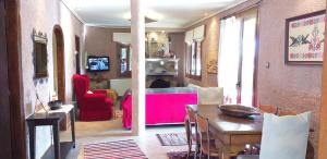 a living room with a table and a red couch at Arachova Houses-Malvina in Arachova