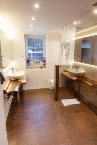 a bathroom with two sinks and a mirror at Ferienwohnung Rotbuche in Tannenberg