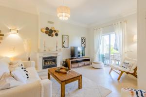 a living room with a white couch and a fireplace at Casa Lomy - Boavista Resort and Spa in Lagos