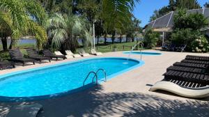 a swimming pool with lounge chairs next to a resort at Refugio del Solís in La Floresta