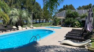 拉弗洛雷斯塔雷富吉德尔索利斯酒店的一个带一束椅子和一把遮阳伞的游泳池