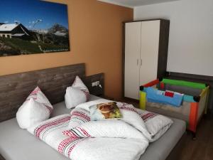 ein Schlafzimmer mit einem Bett mit Kissen und einem Hund auf einem Kissen in der Unterkunft Ferienwohnung Kaufbeurerhausblick in Hinterhornbach