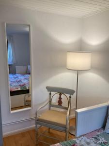 a room with a chair and a lamp and a mirror at Kleines Haus im Grünen in Hamburg
