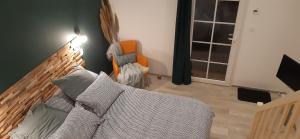 ein Wohnzimmer mit einem Sofa und einem orangenen Stuhl in der Unterkunft Cale 32 - Chambres d'hôtes in Saint-Jean-de-Monts