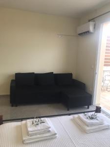 - un canapé noir dans le salon avec une table dans l'établissement Nereids Apartments-Thetis, à Petalidhion