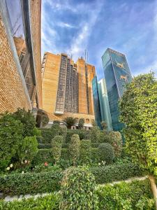 a view of a city with tall buildings and bushes at Babylon Rotana Hotel in Baghdād