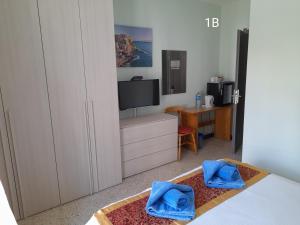 een slaapkamer met een tv en een bed met blauwe handdoeken bij Seabreeze Guest Rooms in St Paul's Bay