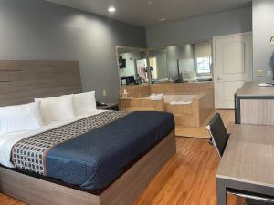 a hotel room with a bed and a bathroom at Palace Inn - Baytown I-10 in Baytown