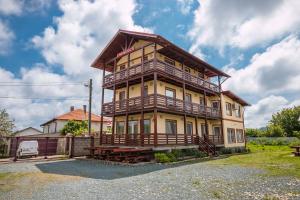 a large yellow house with a large balcony at Casa Luca 2 in Vama Veche