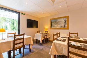 une salle à manger avec des tables et une télévision dans l'établissement Hotel Les Terrasses, à Annecy