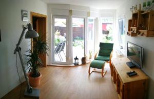 a living room with a television and a chair and a table at "Elbparadies" Ferienhaus am Niegripper See mit Pool in Burg bei Magdeburg