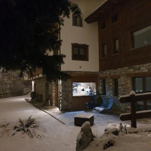 un patio cubierto de nieve frente a un edificio en Agriturismo B&B Chèvres à Cheval, en Aosta