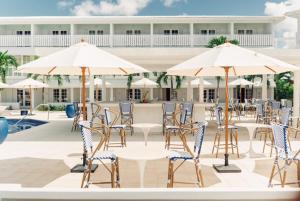 a patio with tables and chairs and umbrellas at The SoCo House - All-Inclusive in Castries