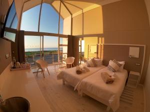 een slaapkamer met een groot bed en een groot raam bij AT THE SEA Boutique Guesthouse in Swakopmund