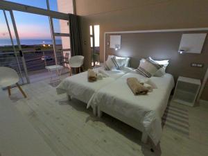 Un dormitorio con una cama grande con dos animales de peluche. en AT THE SEA Boutique Guesthouse en Swakopmund