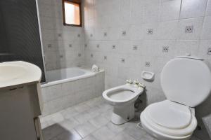 a bathroom with a toilet and a tub and a sink at KM Hosteria Valle Del Sol in San Carlos de Bariloche